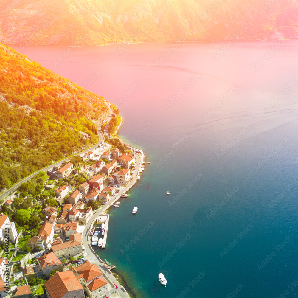 Top view of a beautiful city with red roofs near the sea in the sunlight