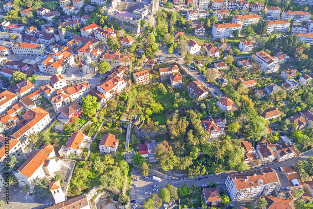 Top view of the city streets with red roofs of houses and highways