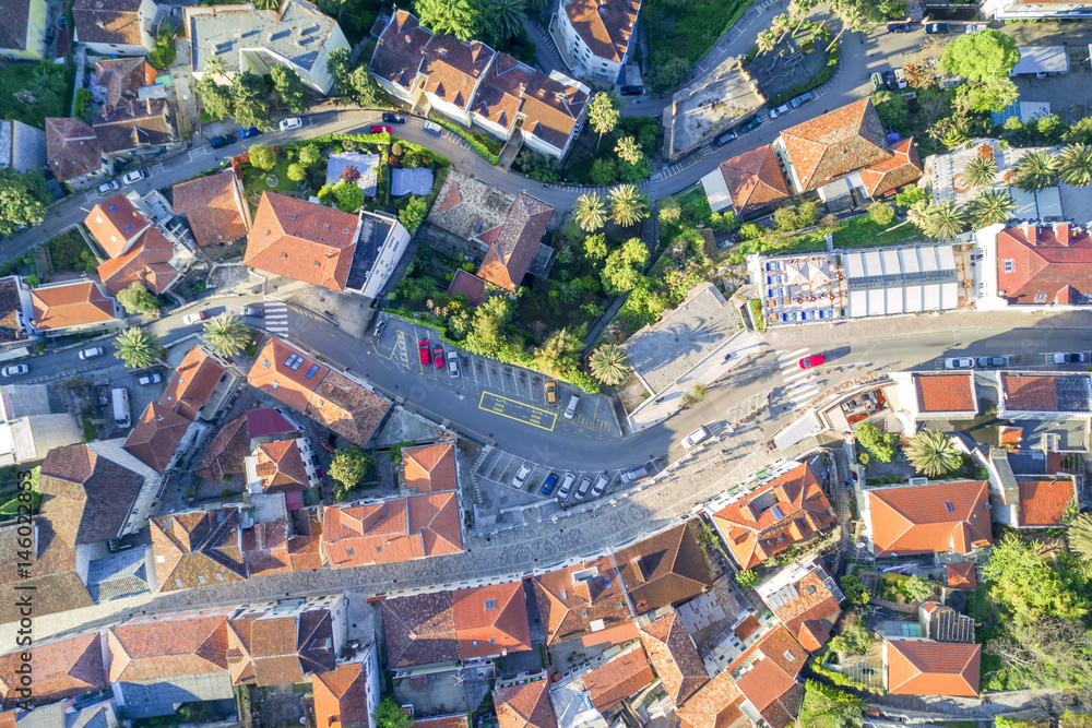 Top view of the city streets with red roofs of houses and highways - obrazy, fototapety, plakaty 