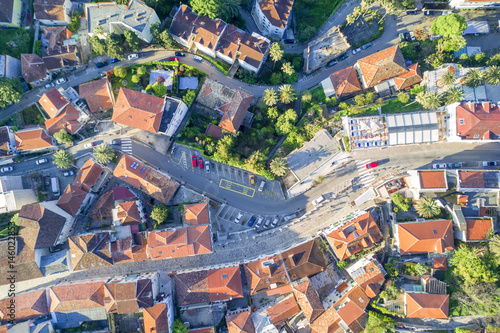 Top view of the city streets with red roofs of houses and highways