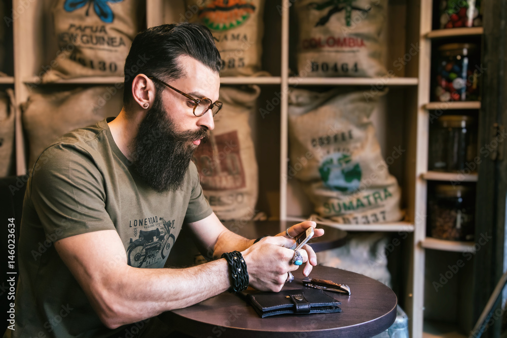 Jeune hipster écrit un sms dans un bar Jeune hipster écrit un sms dans un bar