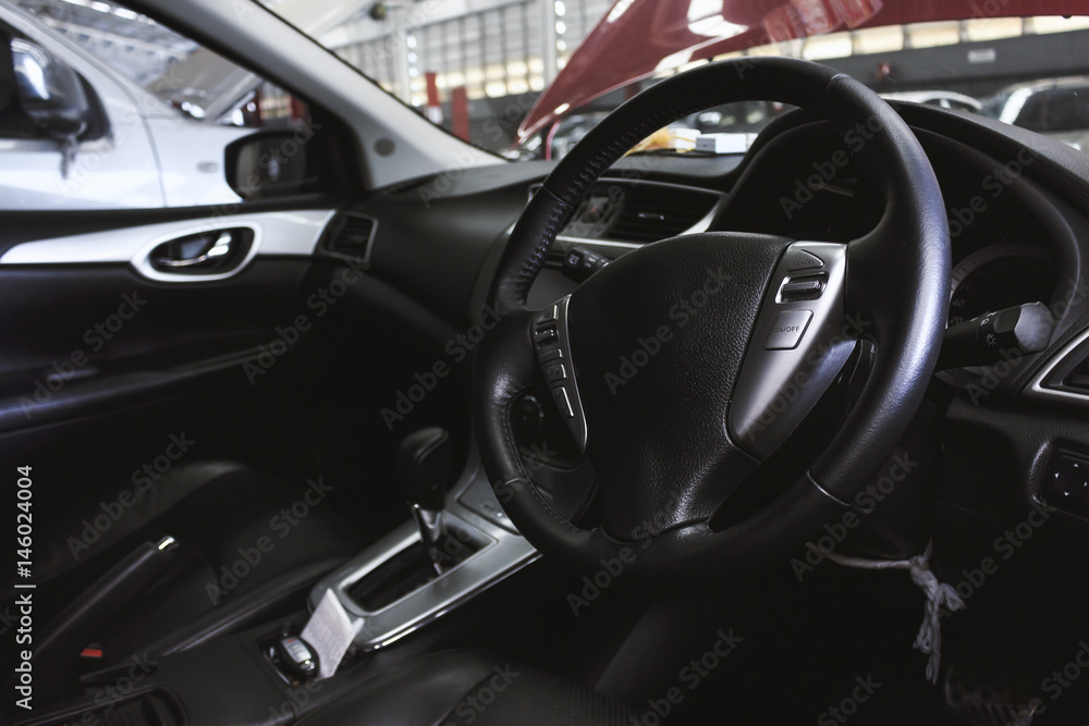 view of the interior of a modern automobile showing the dashboard with soft-focus in the background. over light
