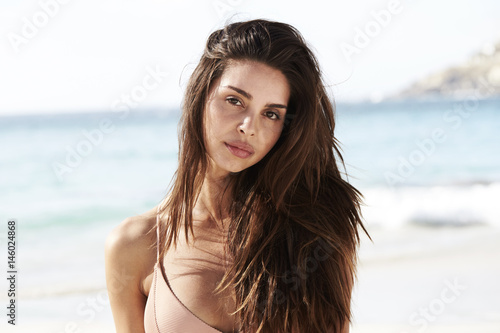 Beach brunette babe looking at camera