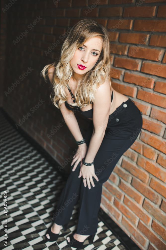 Fototapeta premium The sexual girl stands near wall