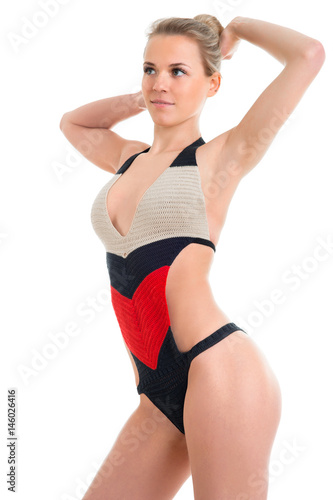 Gorgeous woman in a black red and white swimsuit posing at studio. Knitted swimsuit collection