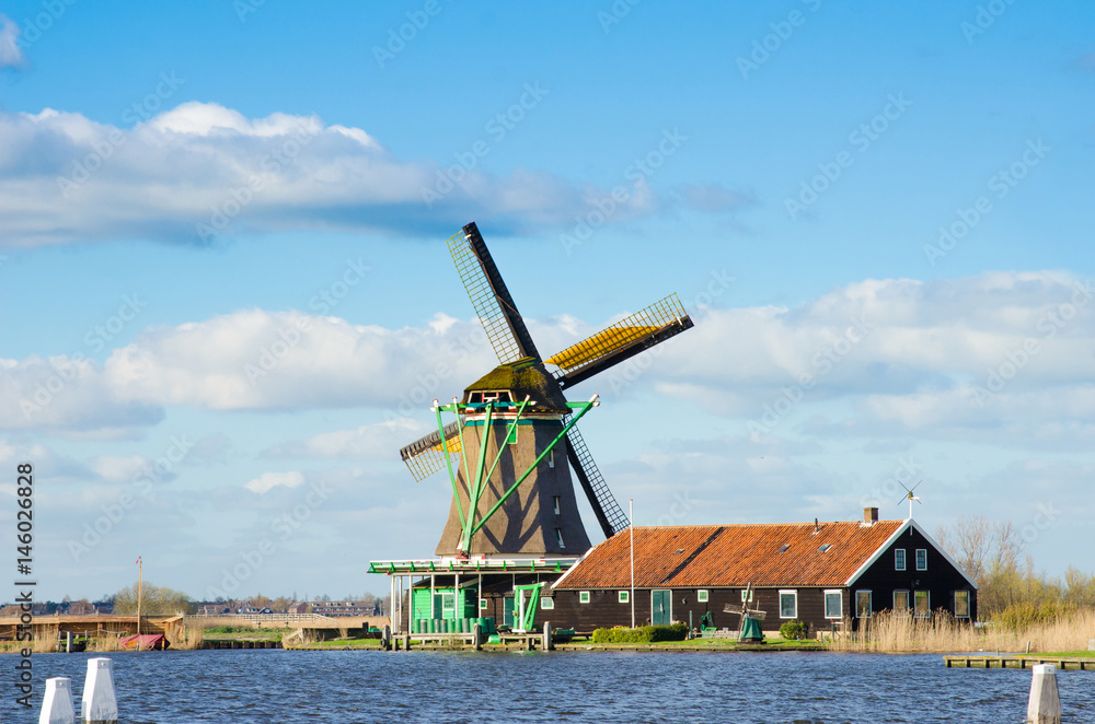 The charming landscape of ponds and windmills in Zaanse Schans, Holland, Europe against the sky