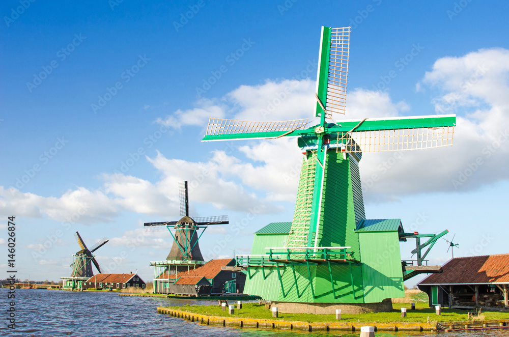 The charming landscape of ponds and windmills in Zaanse Schans, Holland, Europe against the sky