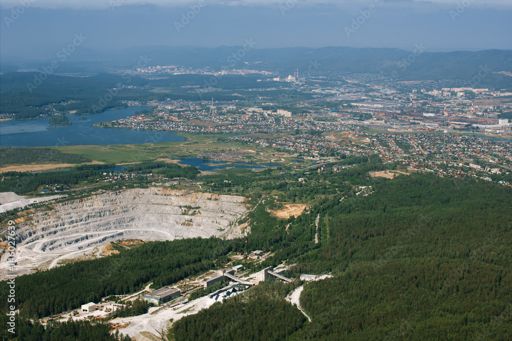 Limestone quarry on the background of the city, aerial photography.