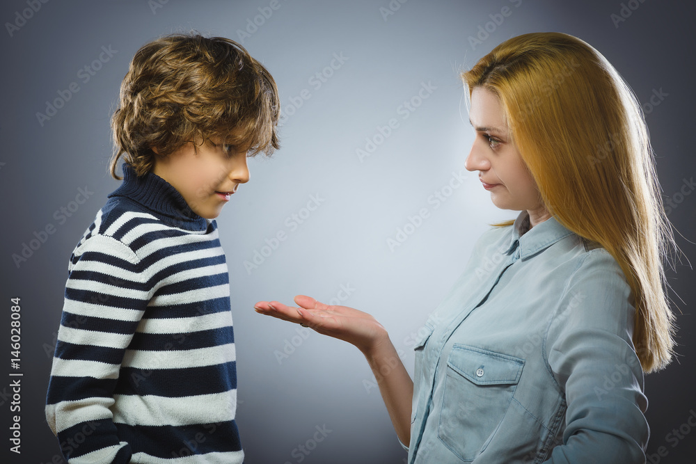 Woman scolding young boy. isolated over gray background