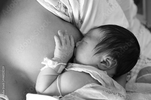 Fotografi infant baby girl is suckling, black and white