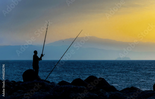 Silueta de un pescador al amanecer. Benalmádena. Málaga. España.