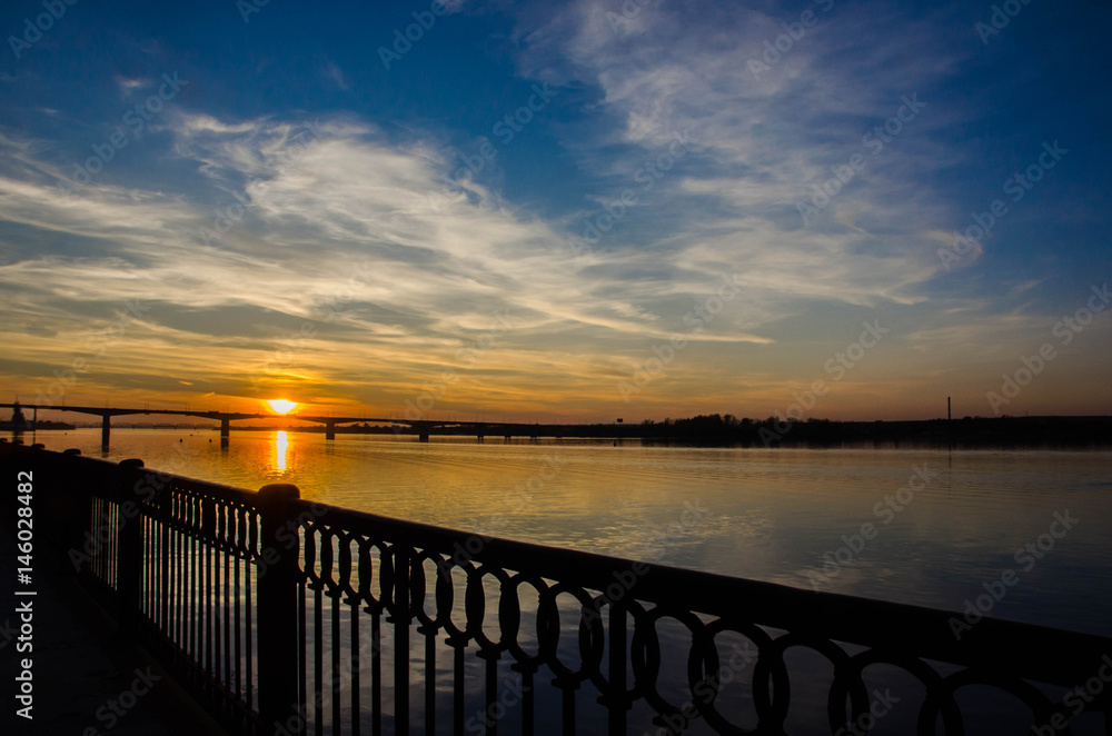 Fototapeta premium Sunset over the river above the bridge