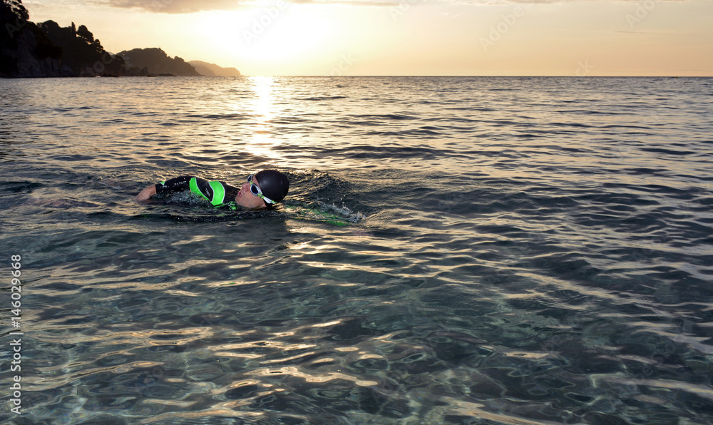 young athlete triathlon in front of a sunrise young athlete triathlon in front of a sunrise