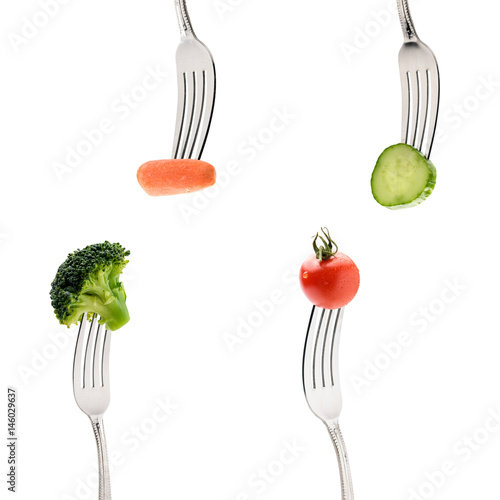 cucumber, cherry tomatoe, carrot and broccoli on forks isolated on white. healthy lifestyle concept