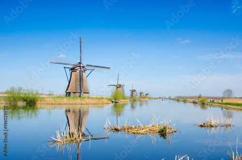 Unique beautiful landscape with windmills in Kinderdijk, Netherlands, Europe against a background of cloudy sky reflection in the water.