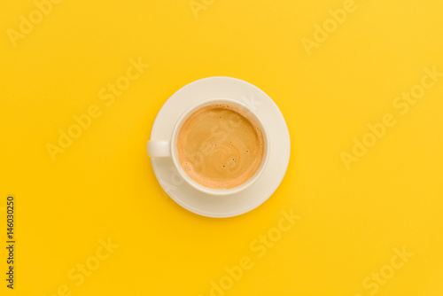 Top view of cup of fresh hot coffee isolated on yellow