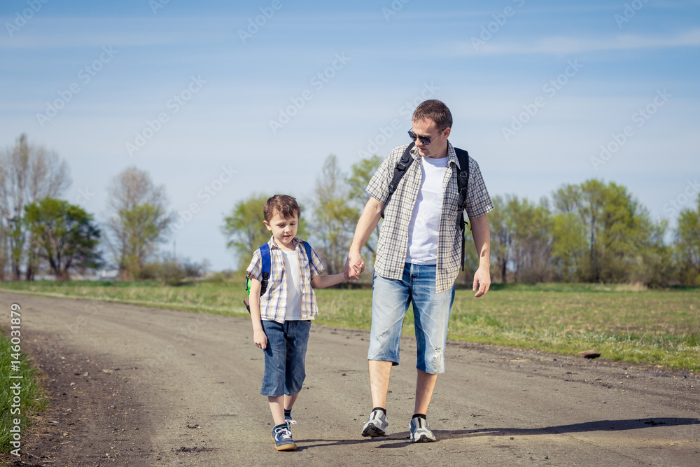 Father and son walking on the road at the day time. Father and son walking on the road at the day time.