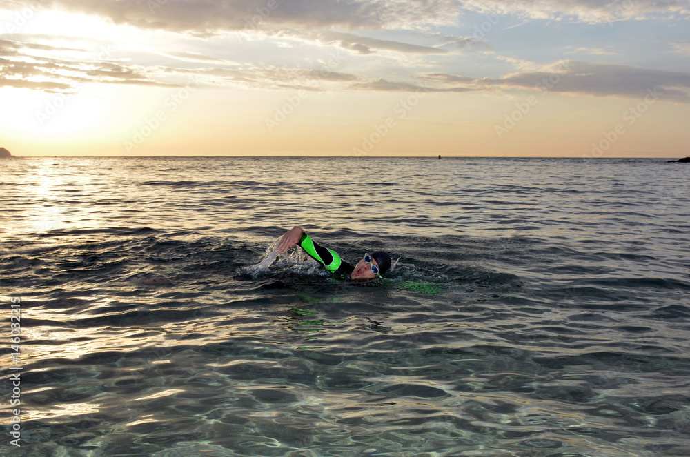 young athlete triathlon in front of a sunrise young athlete triathlon in front of a sunrise