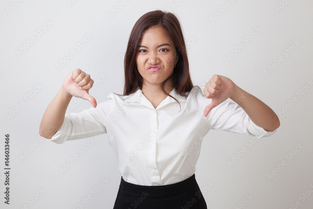 Unhappy Asian girl show thumbs down with both hands. Unhappy Asian girl show thumbs down with both hands.