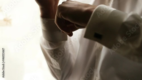 Close up man dressing white shirt. Groom hands buttoning sleeves before ceremony. Mens fashion. Businessman buttoning white shirt sleeves