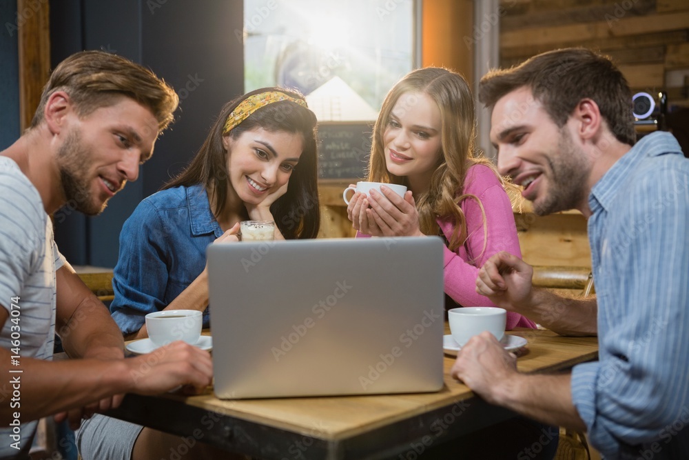 Friends using laptop while having coffee Friends using laptop while having coffee