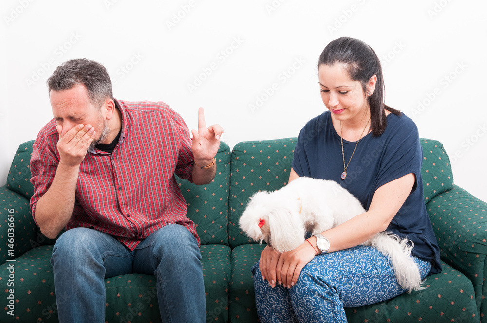 Young male sneezing while talking to his girlfriend Young male sneezing while talking to his girlfriend
