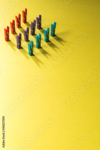 Colorful laundry clips on yellow background. 