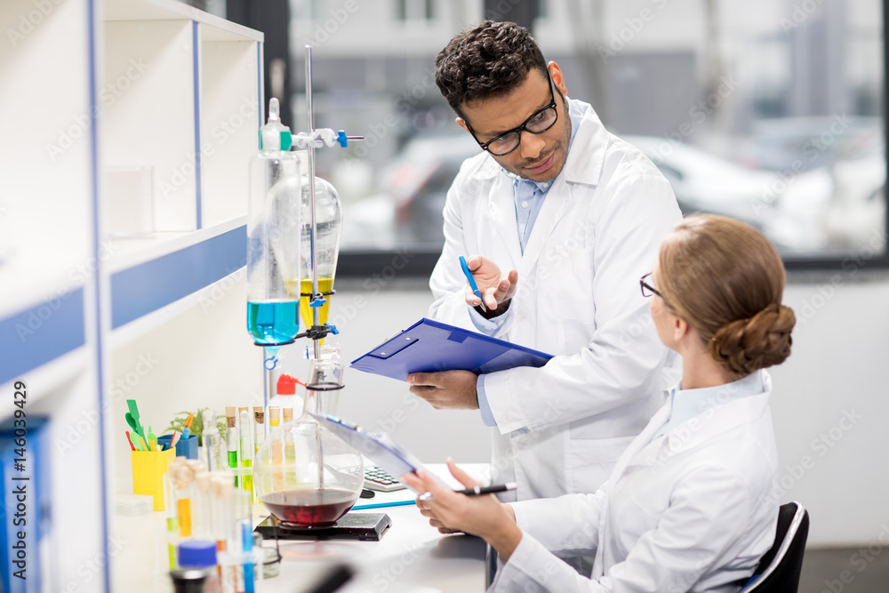 side view of scientists working in laboratory side view of scientists working in laboratory