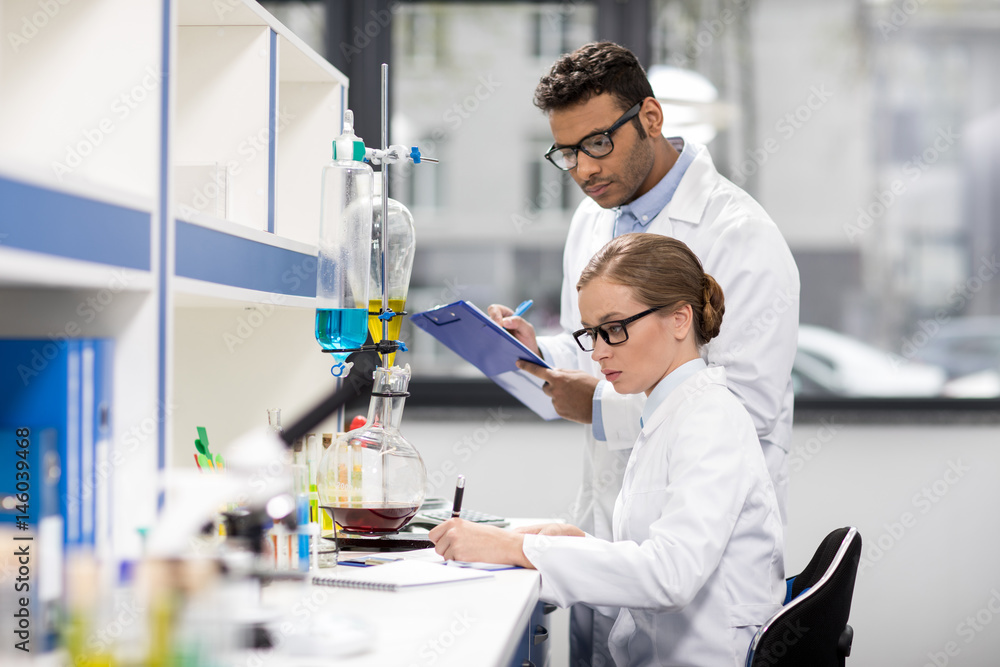 side view of scientists working in laboratory side view of scientists working in laboratory