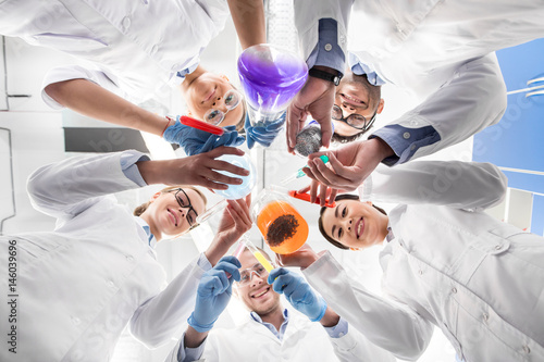 low angle view of scientists holding various test tubes