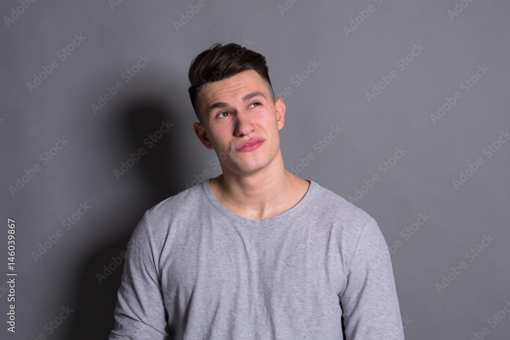 Facial expression, doubtful man looks up Facial expression, doubtful man looks up