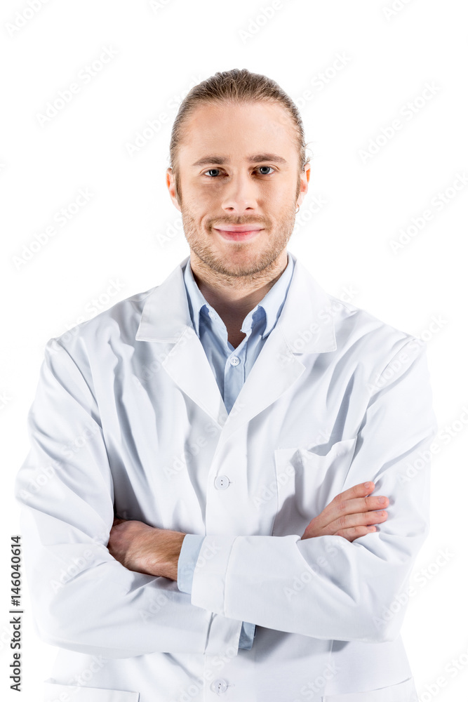 young doctor in white coat with crossed arms looking at camera isolated on white young doctor in white coat with crossed arms looking at camera isolated on white