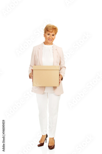 Smile elderly business woman holding cardboard box © Piotr Marcinski
