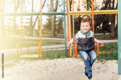 Little boy play on playground with blur park background