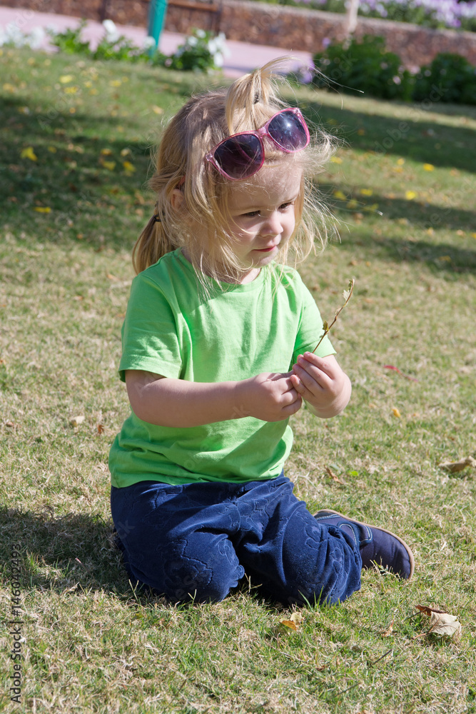 Fototapeta premium small baby boy with adorable face on green grass