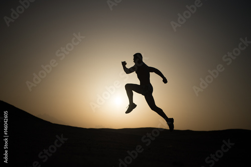 man running silhouette at sunset, young caucasian run in mountain