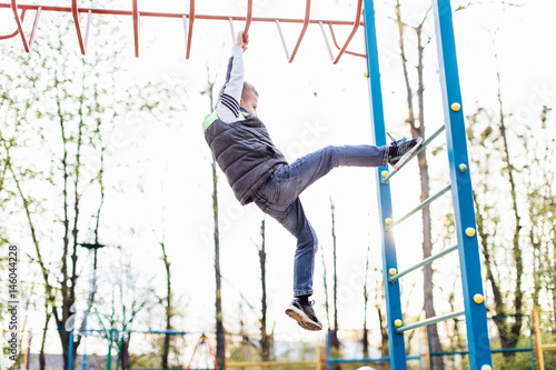 Little boy play on playground with blur park background