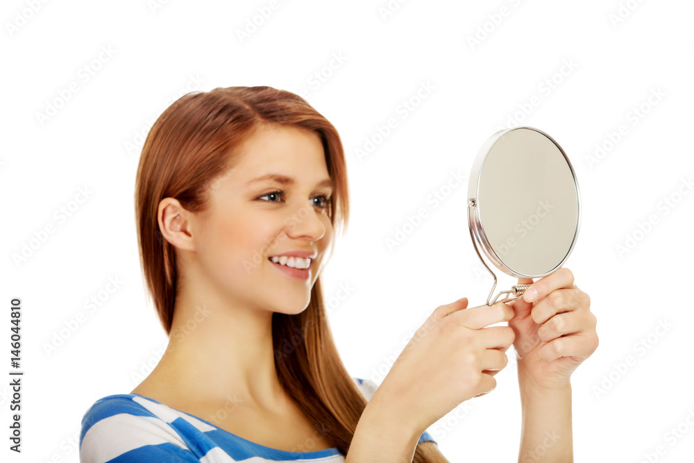 Teenage beautiful woman looking in a mirror Teenage beautiful woman looking in a mirror