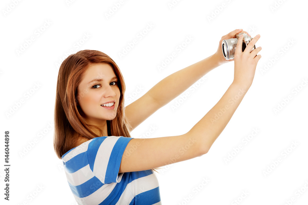 Happy teenage woman taking selfie with classic slr camera Happy teenage woman taking selfie with classic slr camera