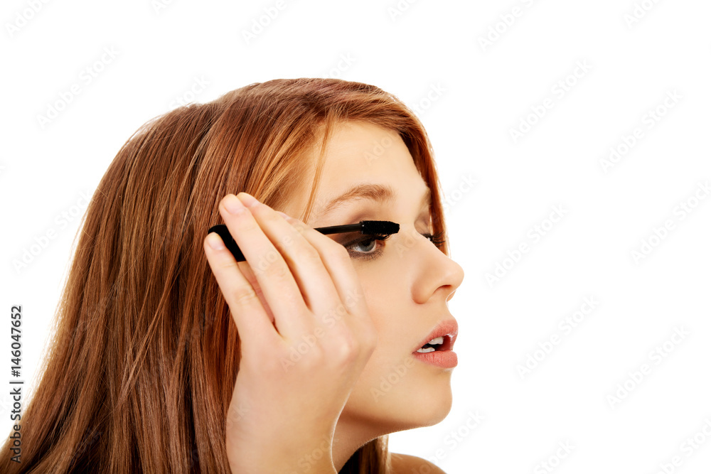 Obraz premium Teenage beautiful woman applying mascara