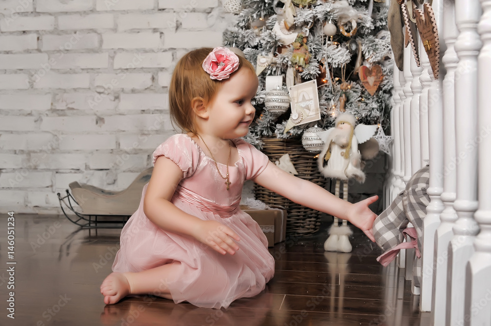 Little girl in a pink dress in retro Christmas interior.