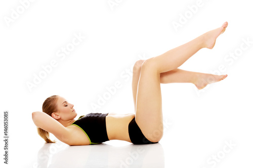 Young woman doing stretching exercise on the floor © Piotr Marcinski