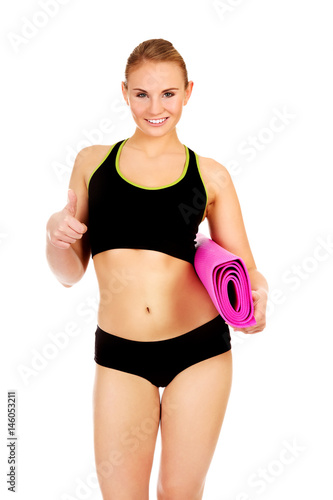 Woman ready for workout with yoga mats and thumb up © Piotr Marcinski