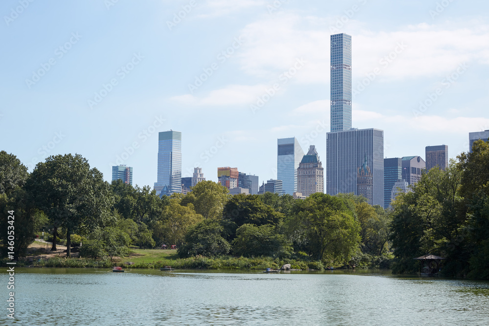 New York city skyline with 432 Park Avenue skyscraper from Central Park with pond view