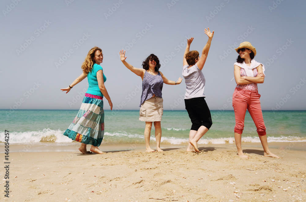 Portrait of four  40 years old women walking on seaside
