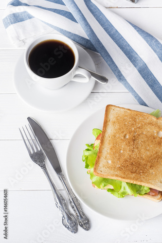 Breakfast with sandwich and coffee.