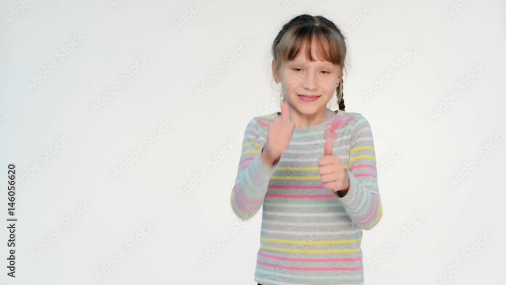 Little girl jumping and turning to camera gesturing thumb up with enthusiasm, locked down real time video Little girl jumping and turning to camera gesturing thumb up with enthusiasm, locked down real time video
