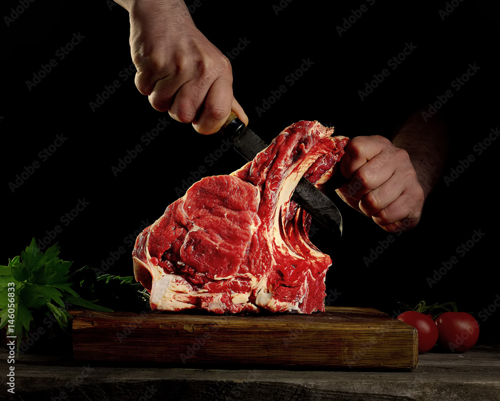 Man cutting raw beef meat.