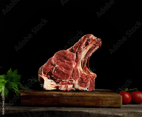 Raw beef meat on a wooden table close up on a dark background
