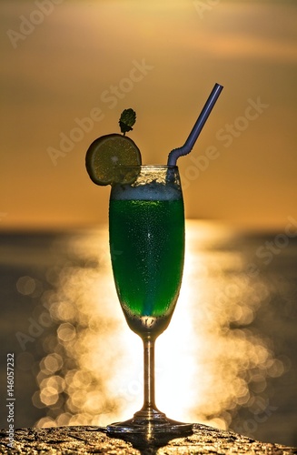 Glass of drink is on a beach table